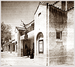 A man is standing in front of a building with a sign that says “Casa de los Muertos". AI generated content