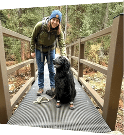 A woman is standing on a bridge with her dog. AI generated content